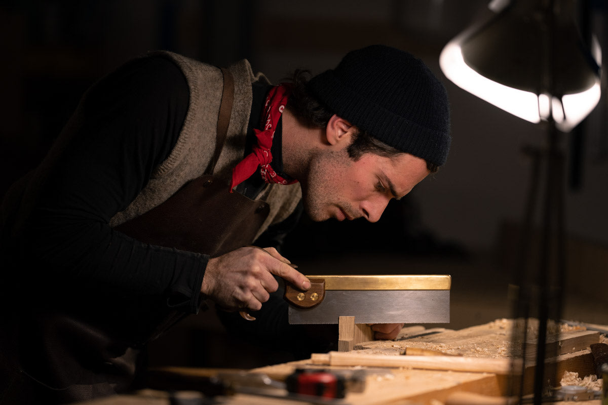 Zdenko sawing with a backsaw in the workshop at Fornebu